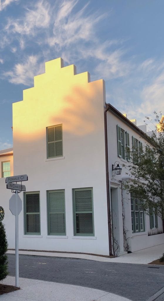 alt= "Alys Beach, Florida, at sunset when the glow of the day is reflected on the buildings."